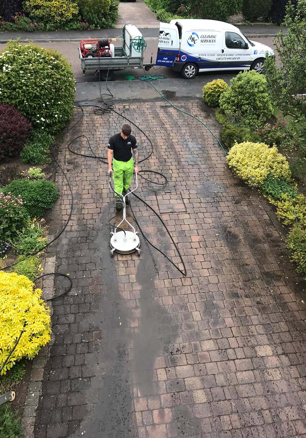 Man power washing driveway